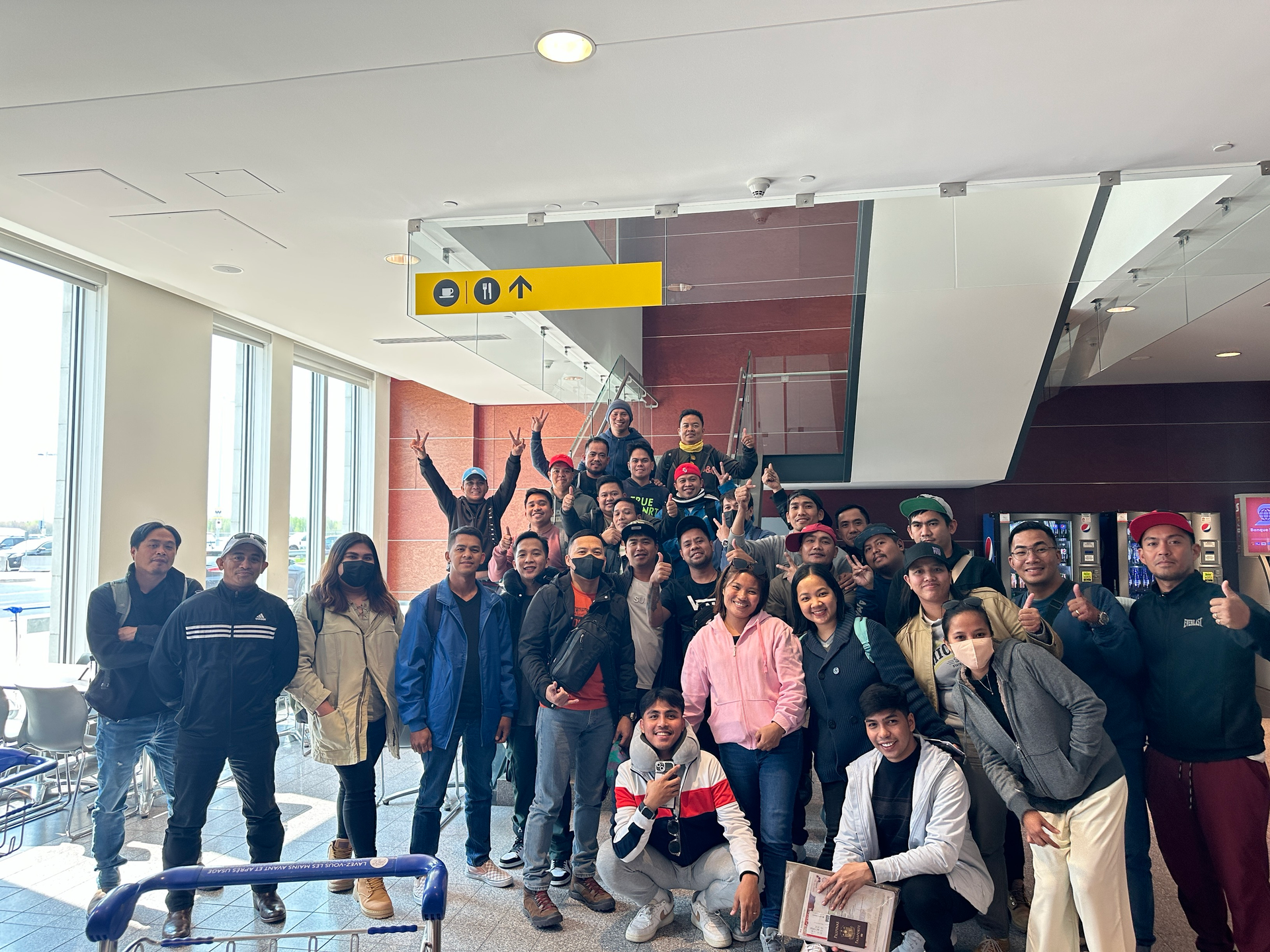 Un groupe de personnes pose pour une photo dans un aéroport.