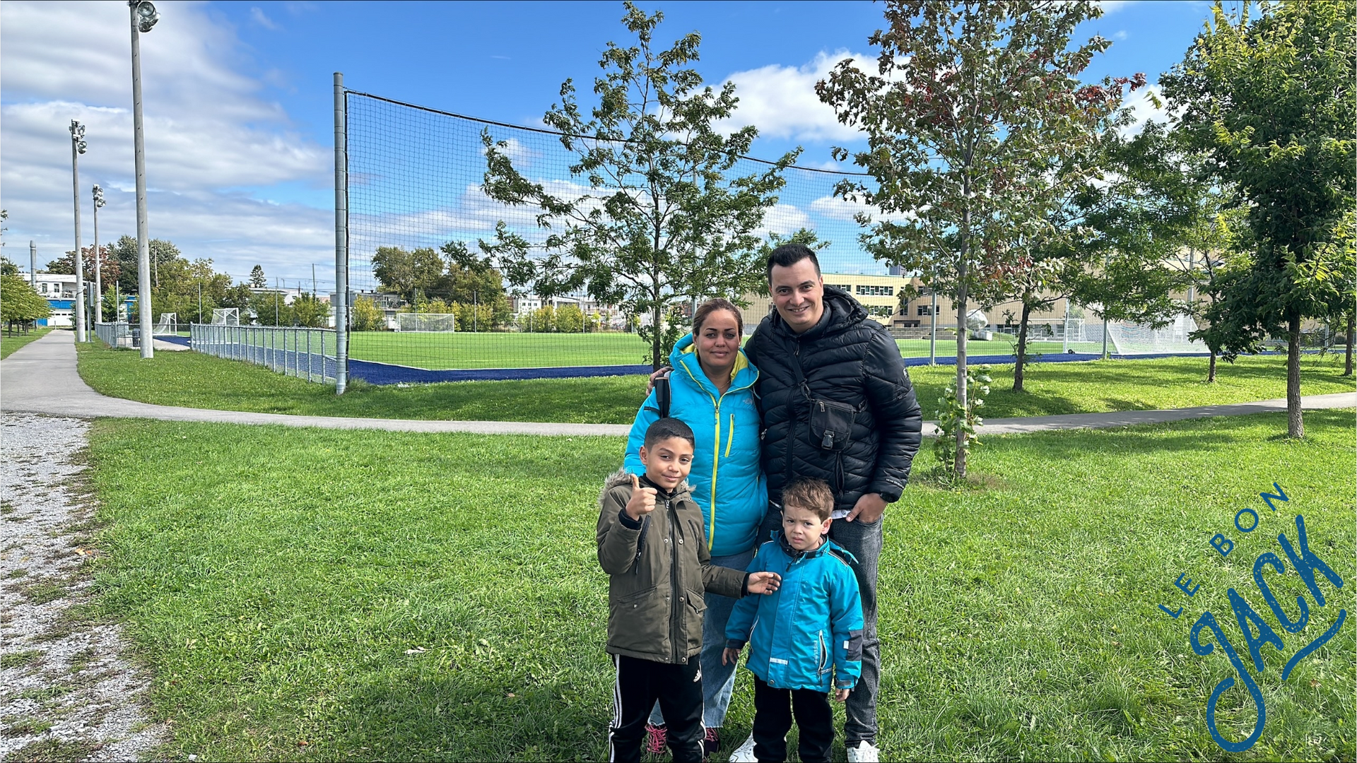 Une famille pose pour une photo dans un parc.