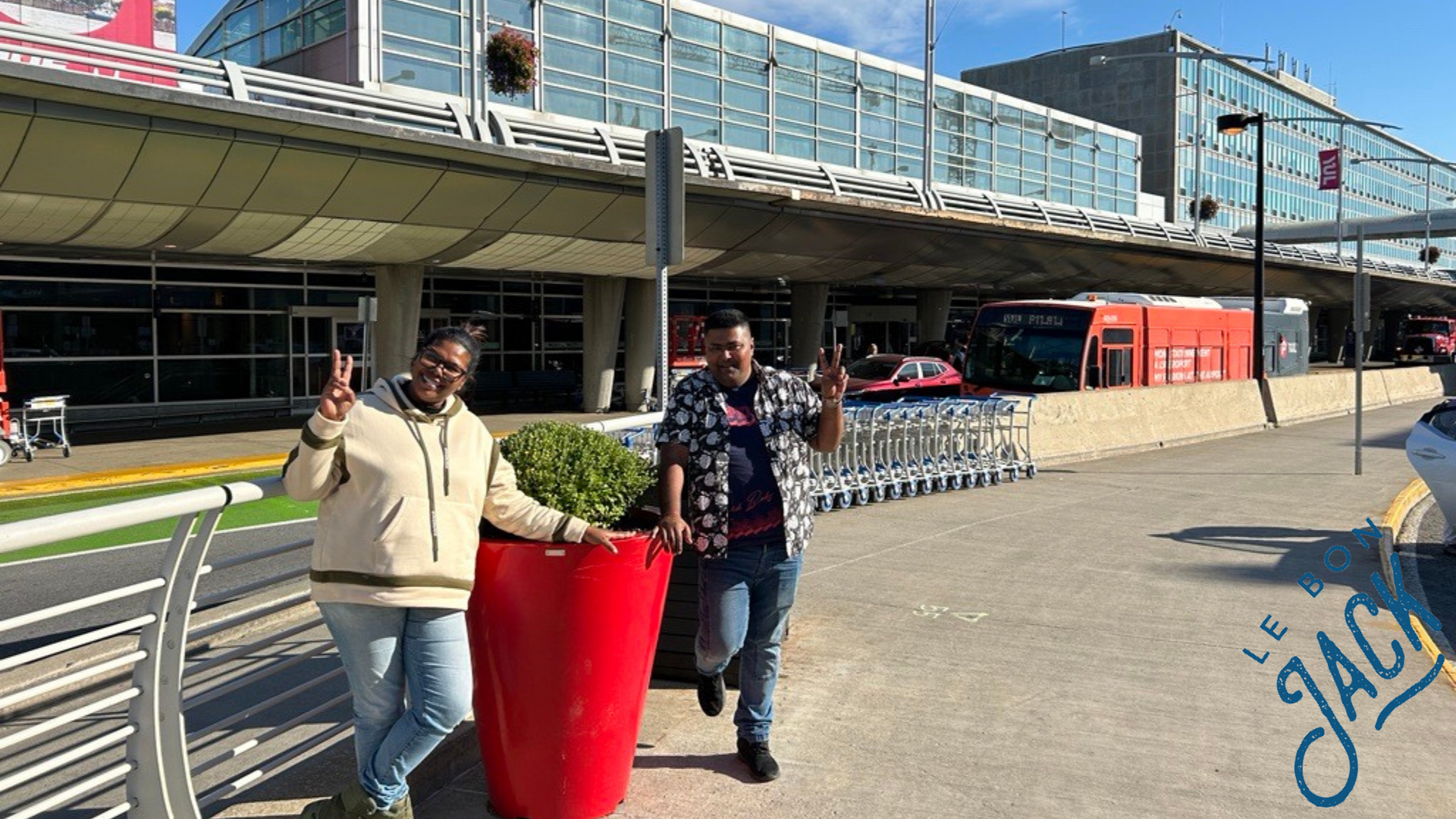 Un homme et une femme se tiennent côte à côte devant un aéroport.