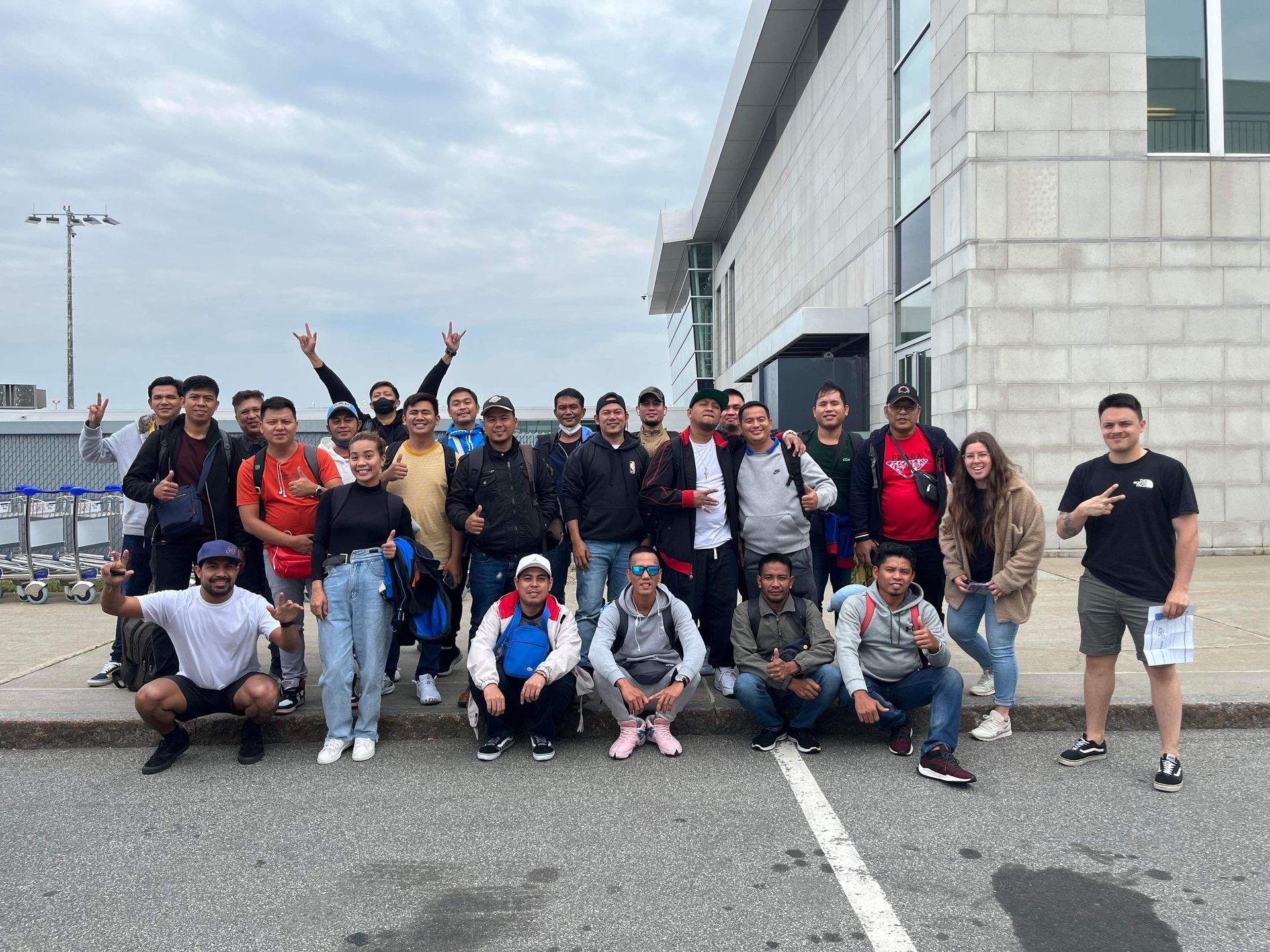 Un groupe de personnes pose pour une photo devant un bâtiment.