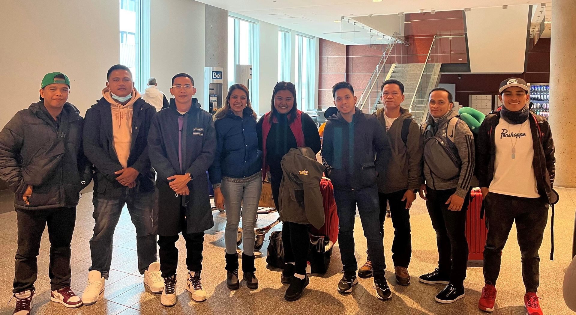 Un groupe de personnes se tiennent côte à côte dans une pièce.