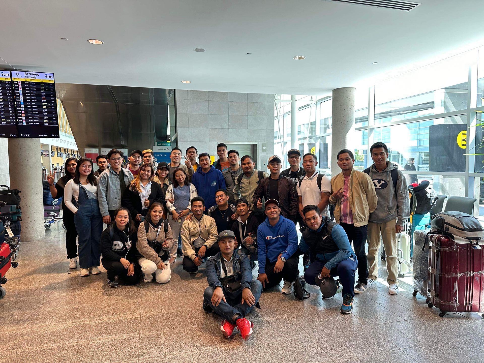 Un groupe de personnes pose pour une photo dans un aéroport.
