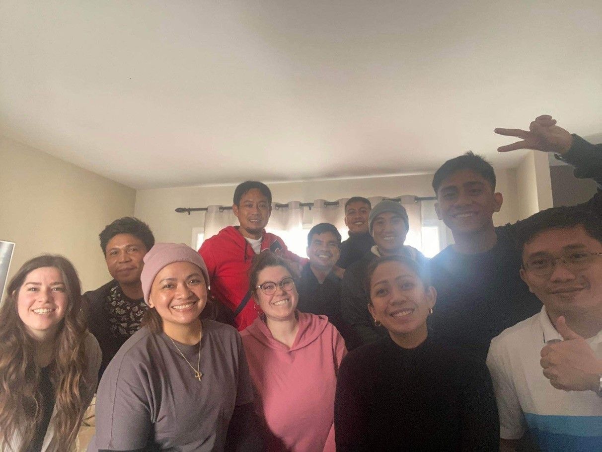 Un groupe de personnes pose pour une photo dans un salon.