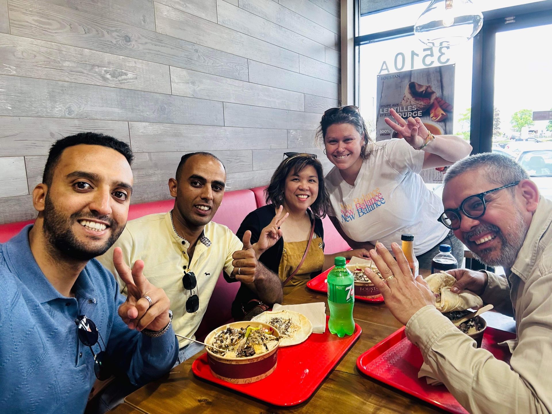 Un groupe de personnes sont assises à une table dans un restaurant en train de manger.