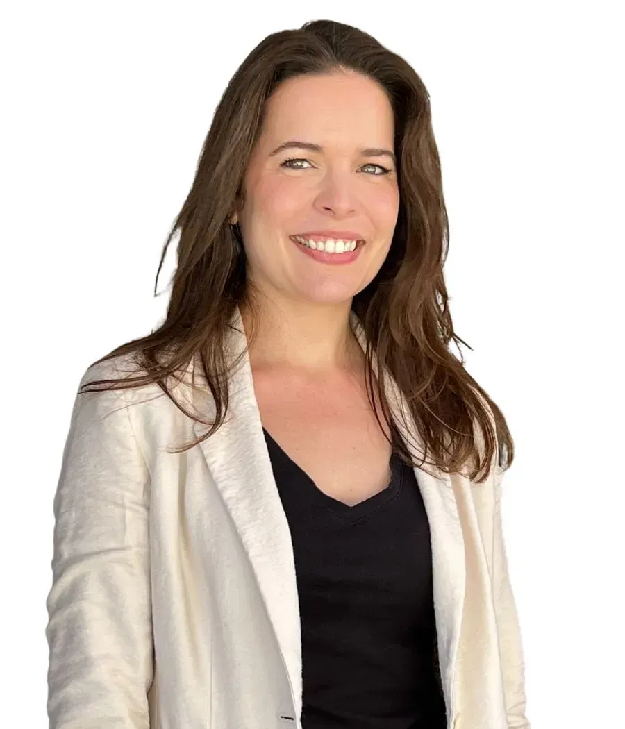A woman wearing a white jacket and a black shirt is smiling.