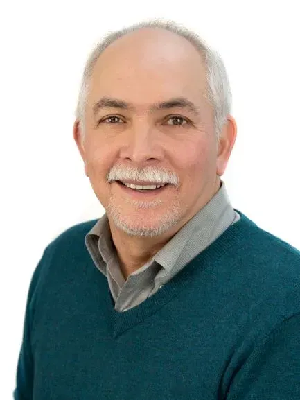 A man with gray hair, smiling