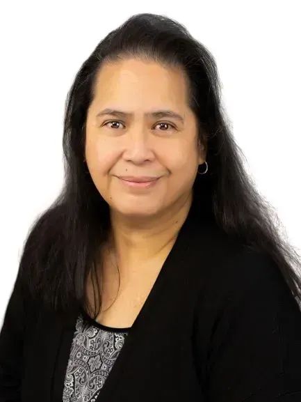 A woman with long black hair is wearing a black jacket and smiling for the camera.