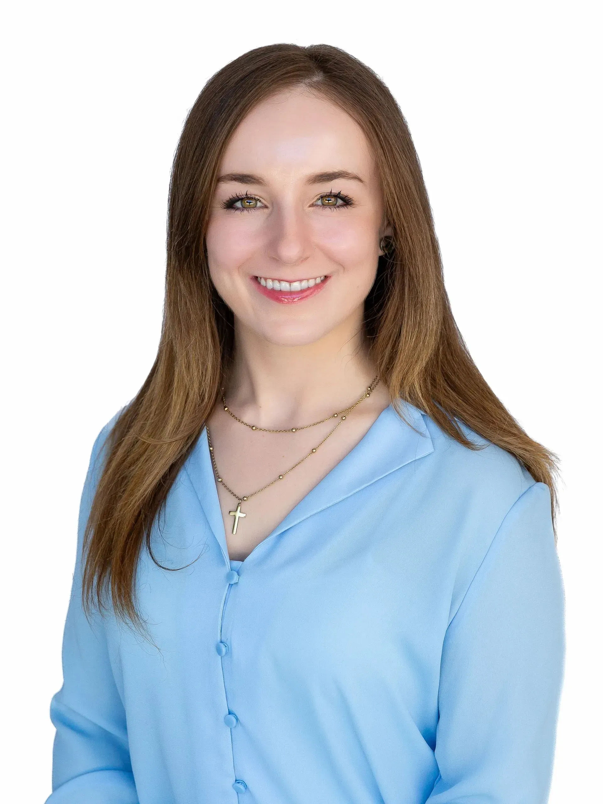A woman in a blue shirt and necklace is smiling for the camera.