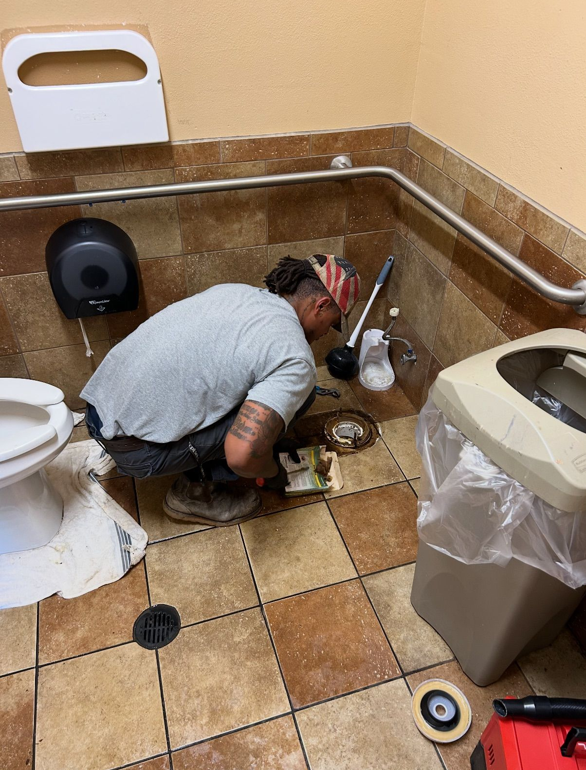 Person with gloves installing a sink drain in a white sink.