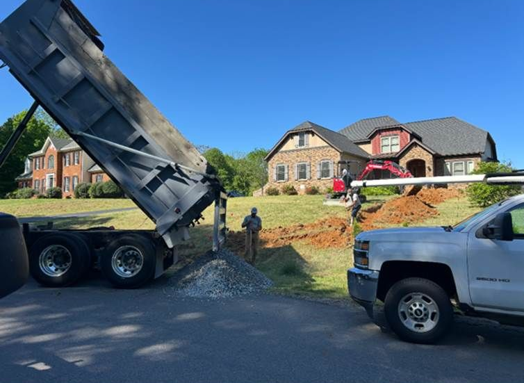 Two large, parallel pipes lay in a deep trench. Construction site, outdoor setting.