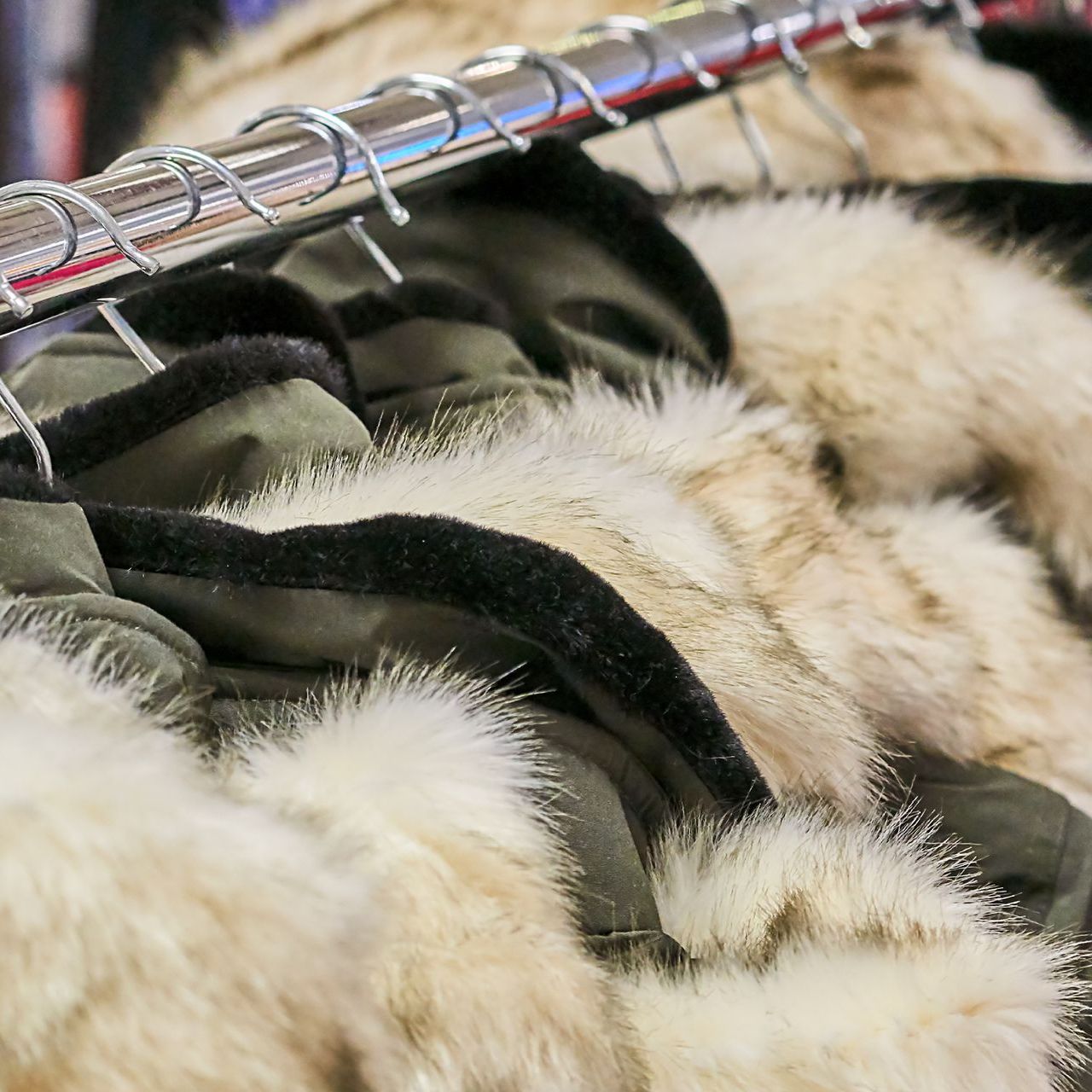 Una fila di pellicce appese a un attaccapanni in un negozio.