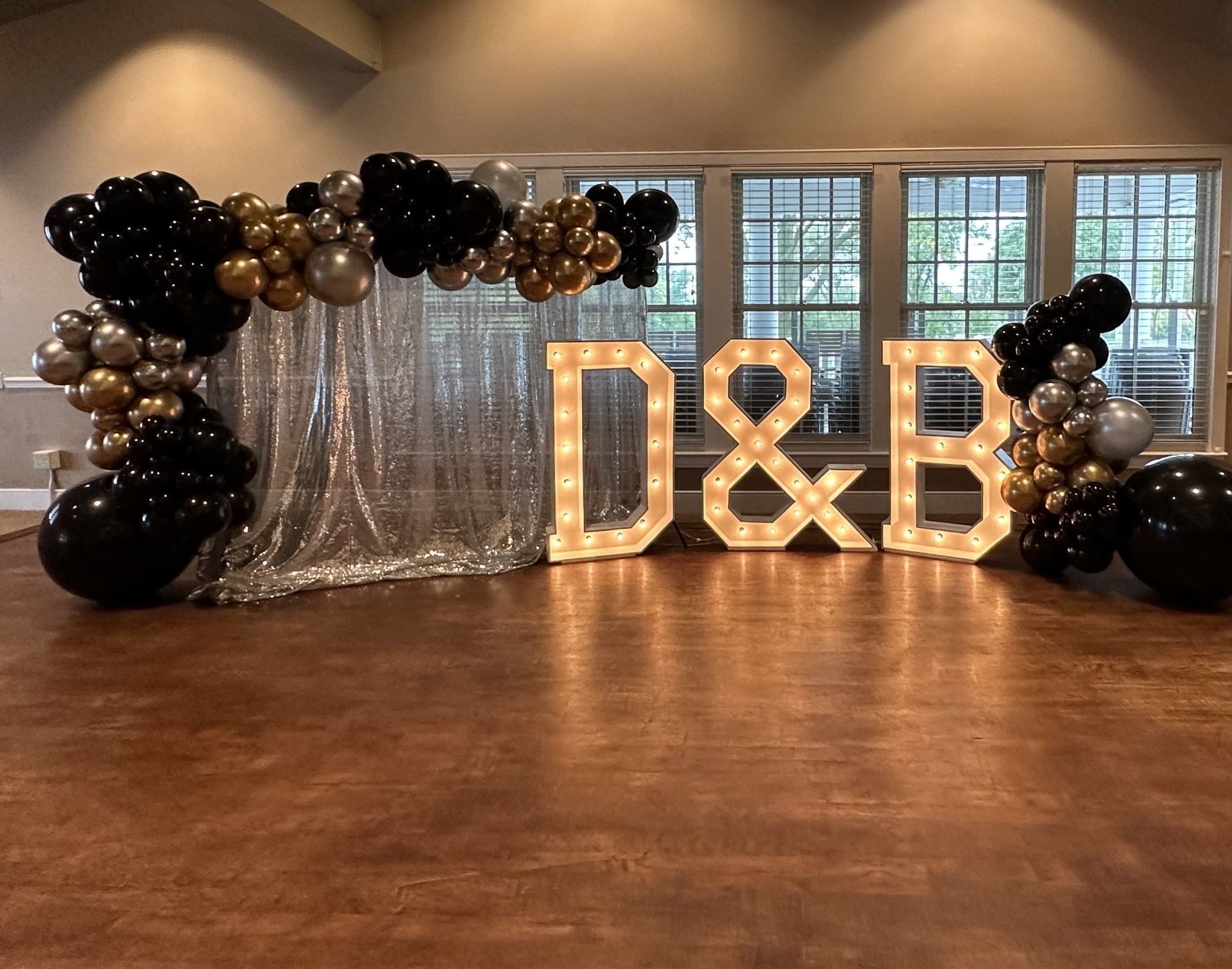 A room with balloons and lighted letters that say d & b