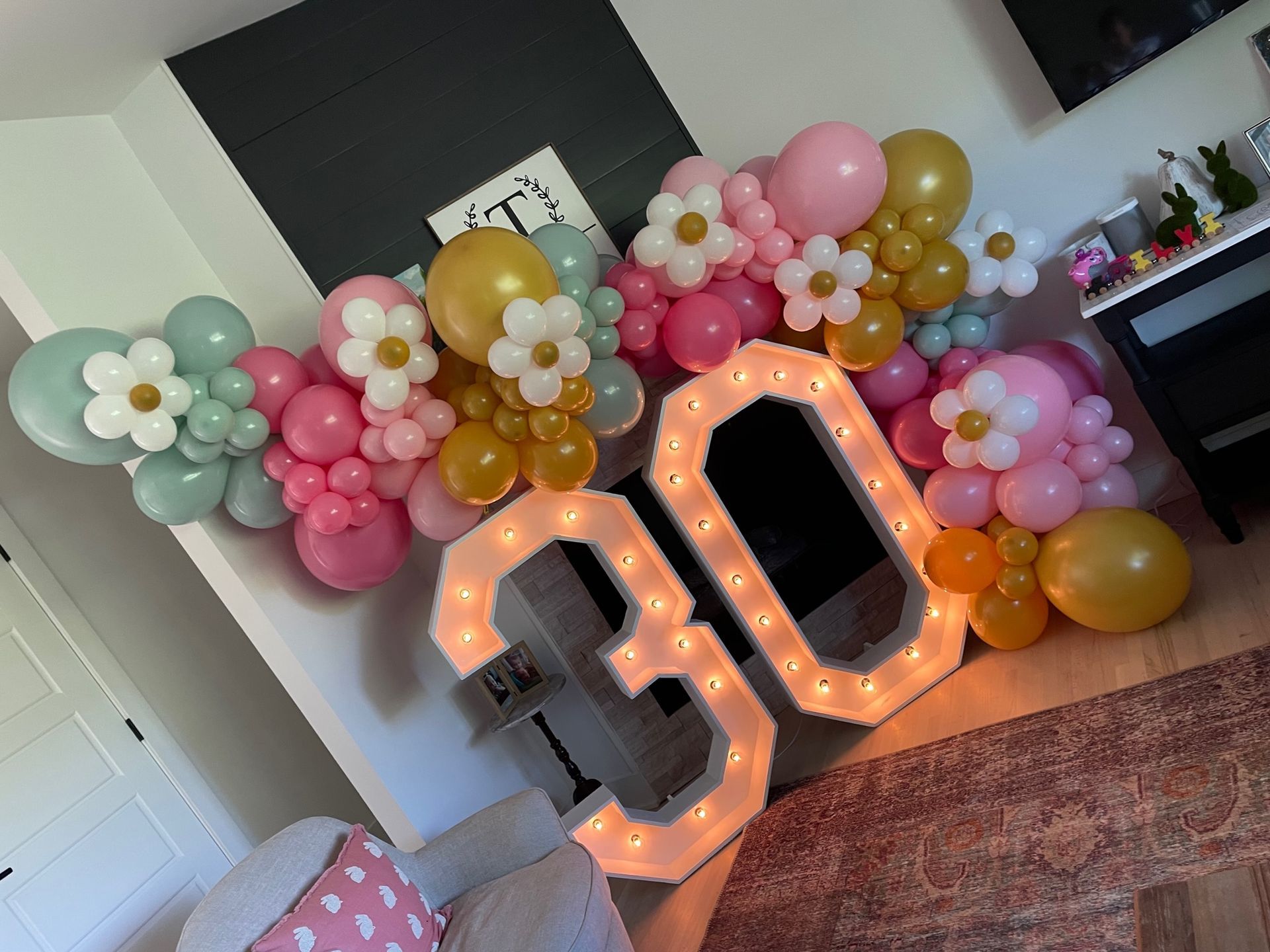 A room decorated with balloons and a lighted number 30.