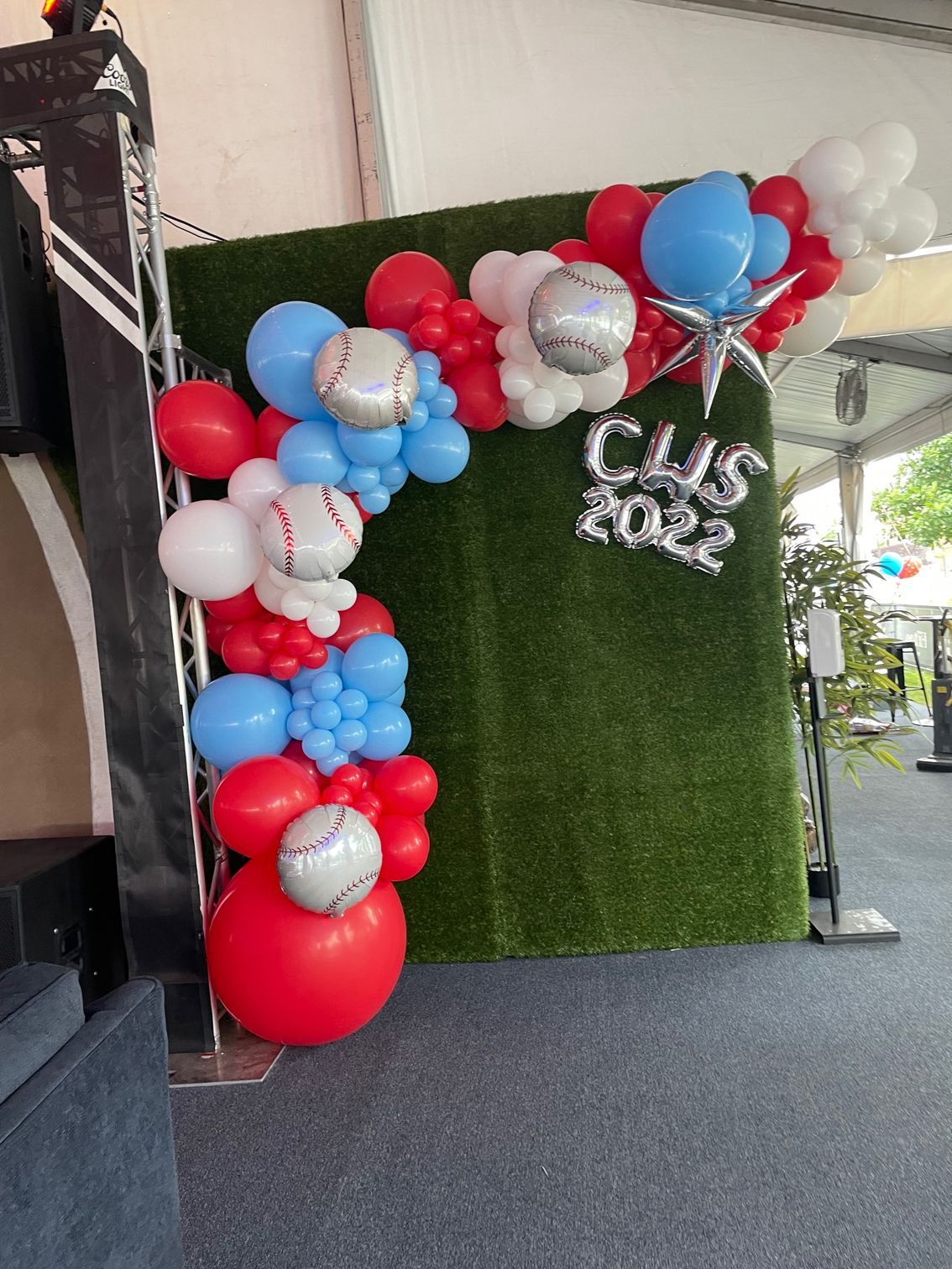 A bunch of red , white and blue balloons on a wall