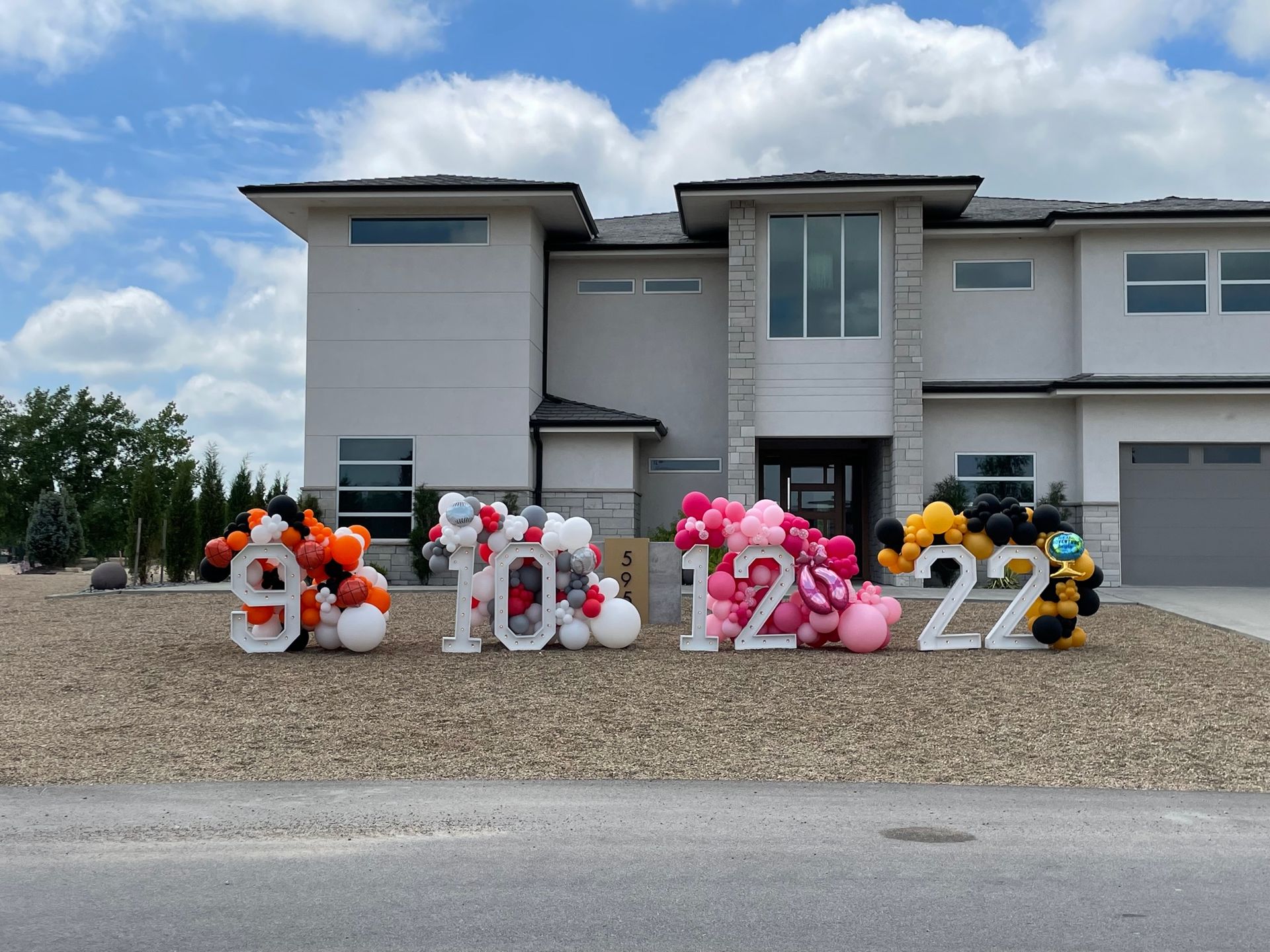 A large white house with balloons in front of it.