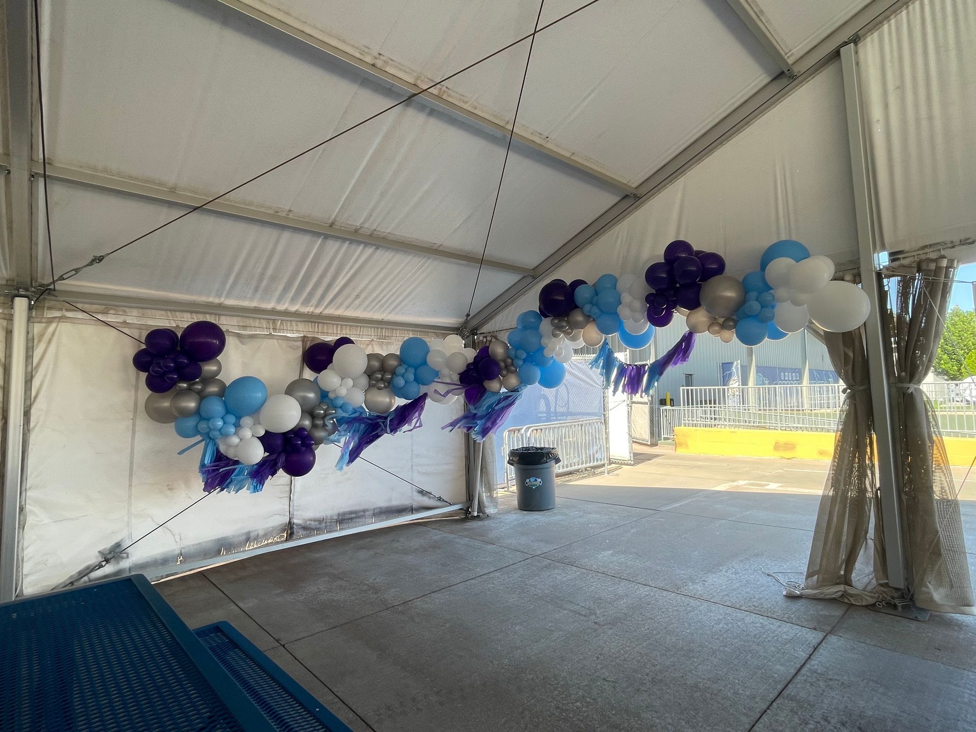A white tent with balloons hanging from the ceiling