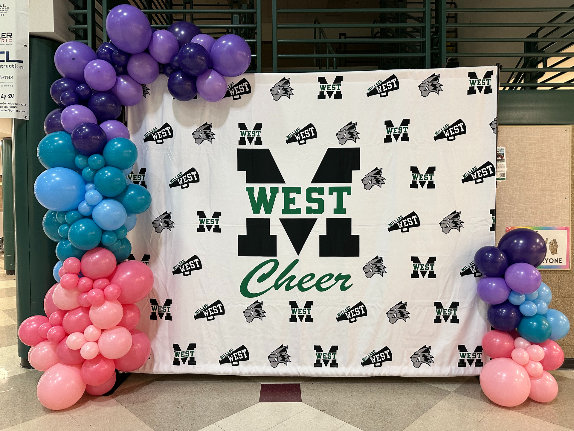 A west m cheer banner is surrounded by balloons