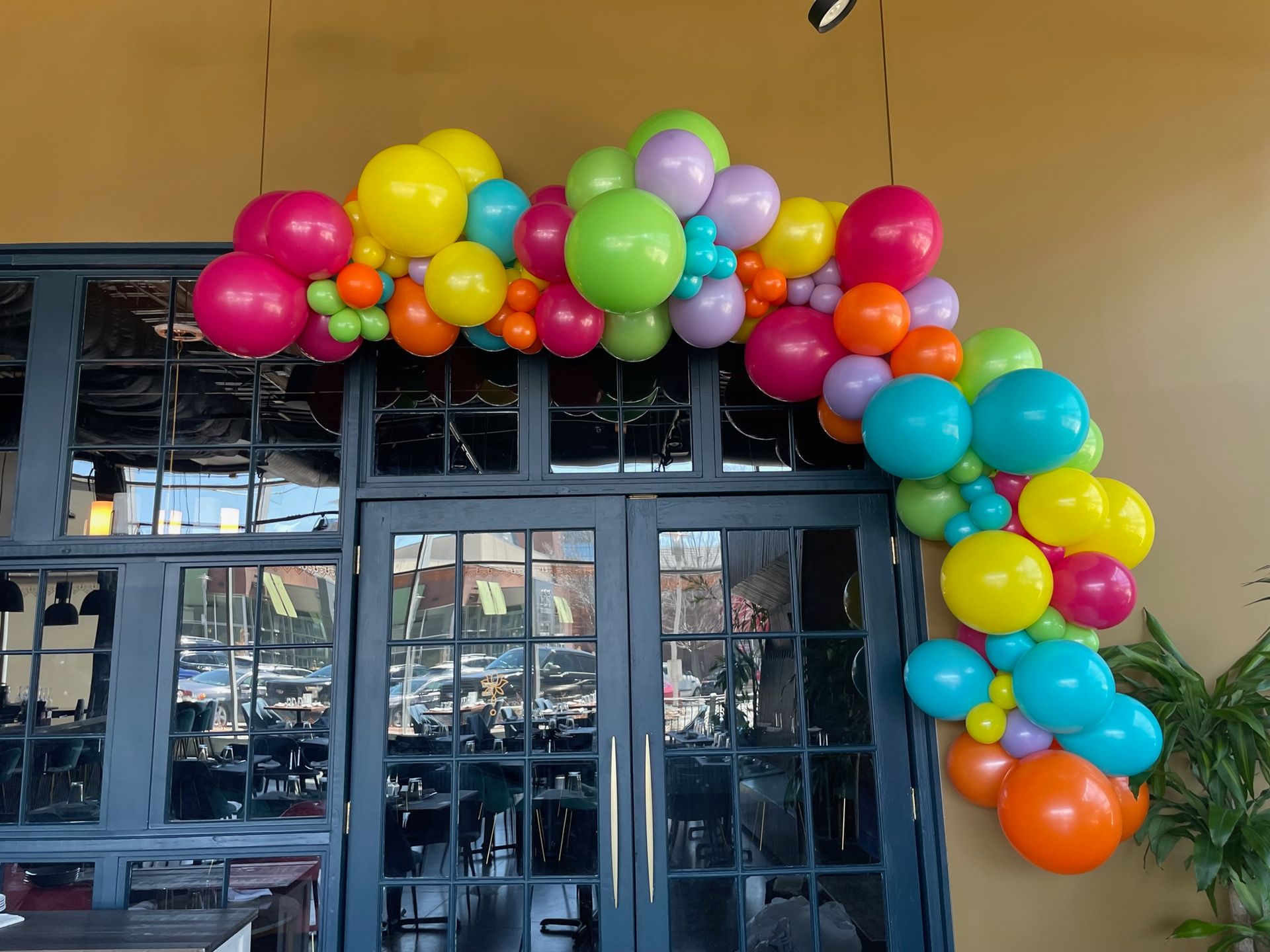 A bunch of colorful balloons are hanging over a doorway