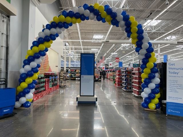 A blue and yellow balloon arch in a store