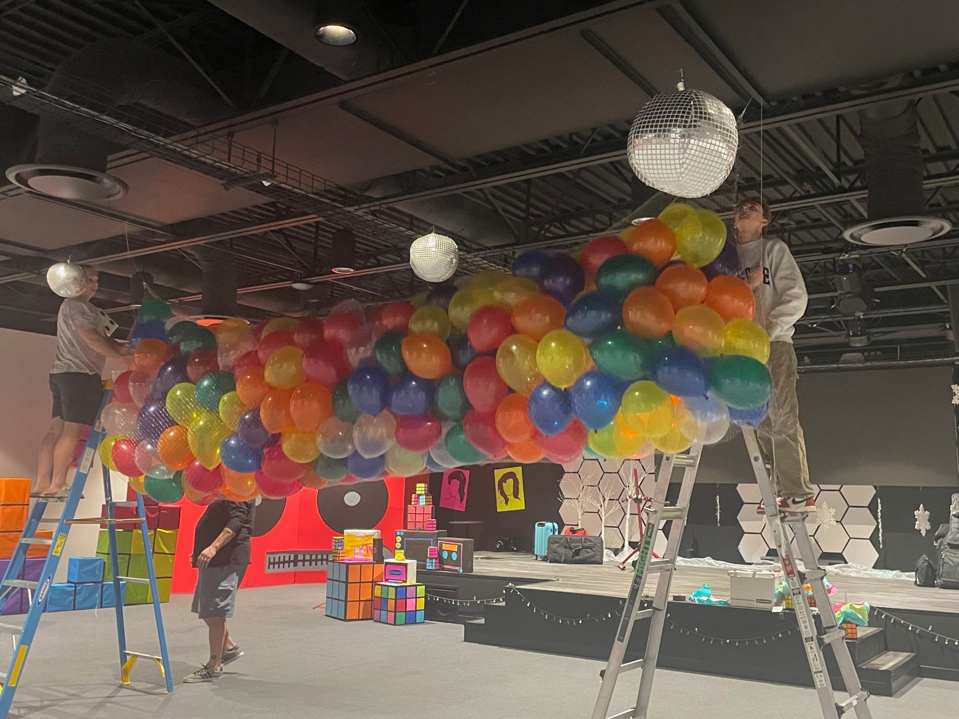 A bunch of balloons are hanging from the ceiling in a room.