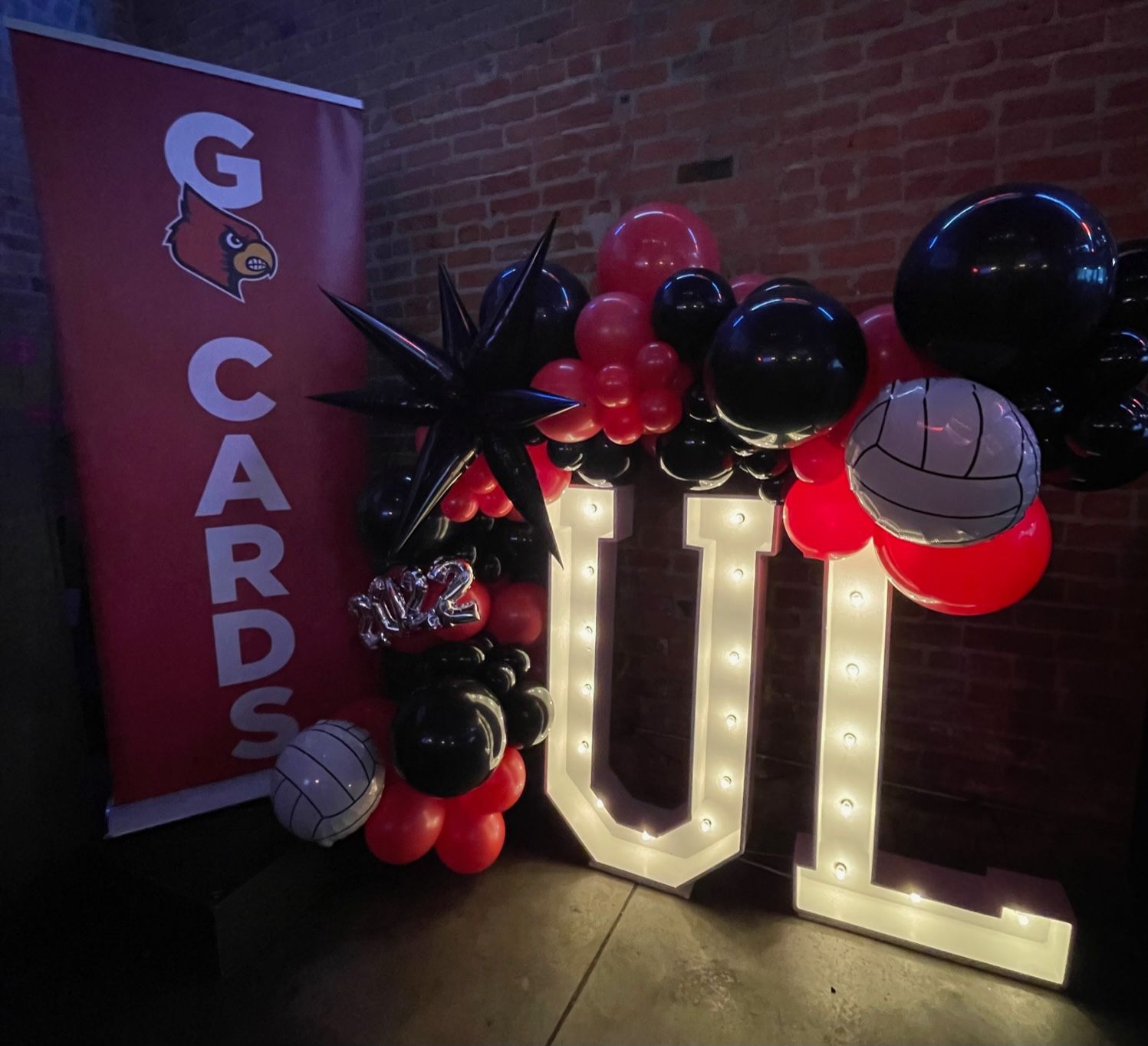 A sign that says g cards is surrounded by balloons and lights