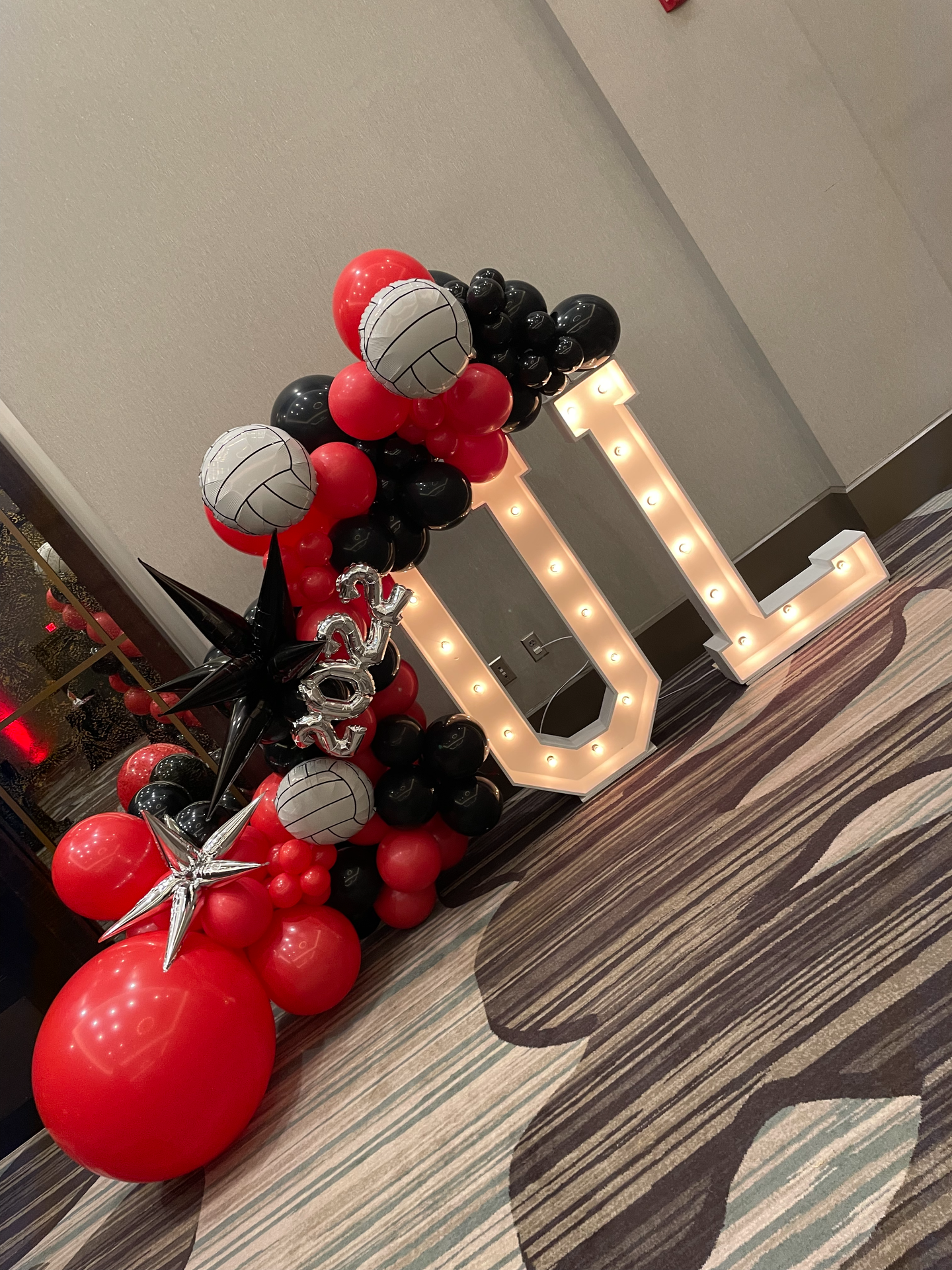A large letter u is surrounded by red and black balloons.
