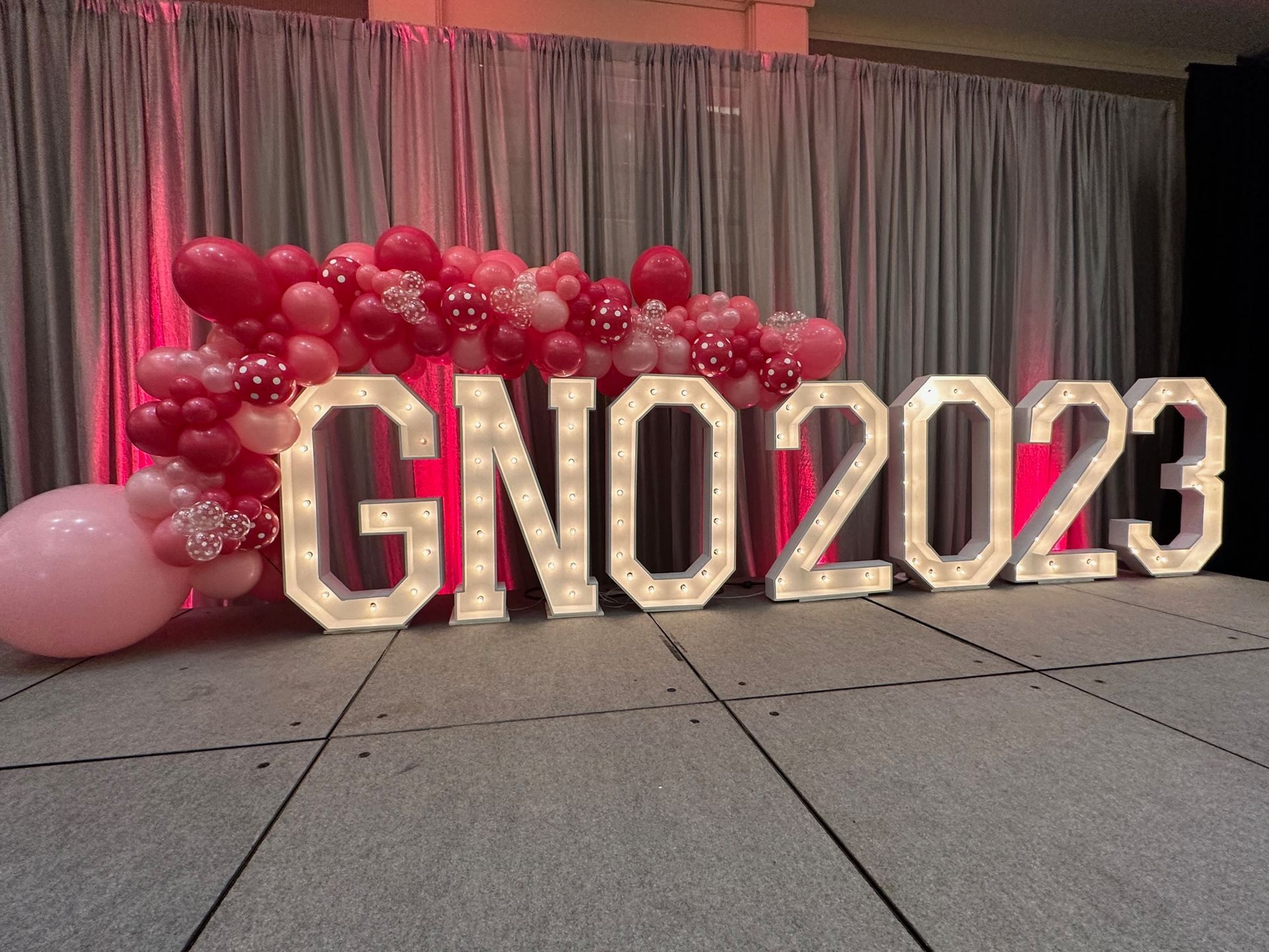 A large sign that says gno 2023 is surrounded by pink balloons.