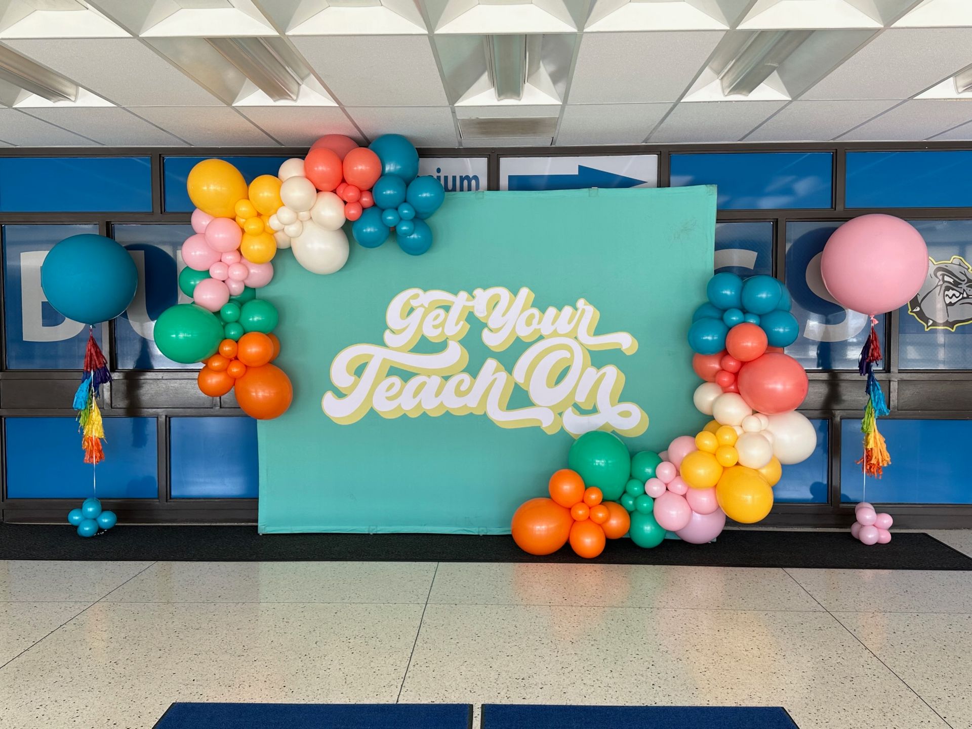 A wall with balloons and a sign that says get your teach on