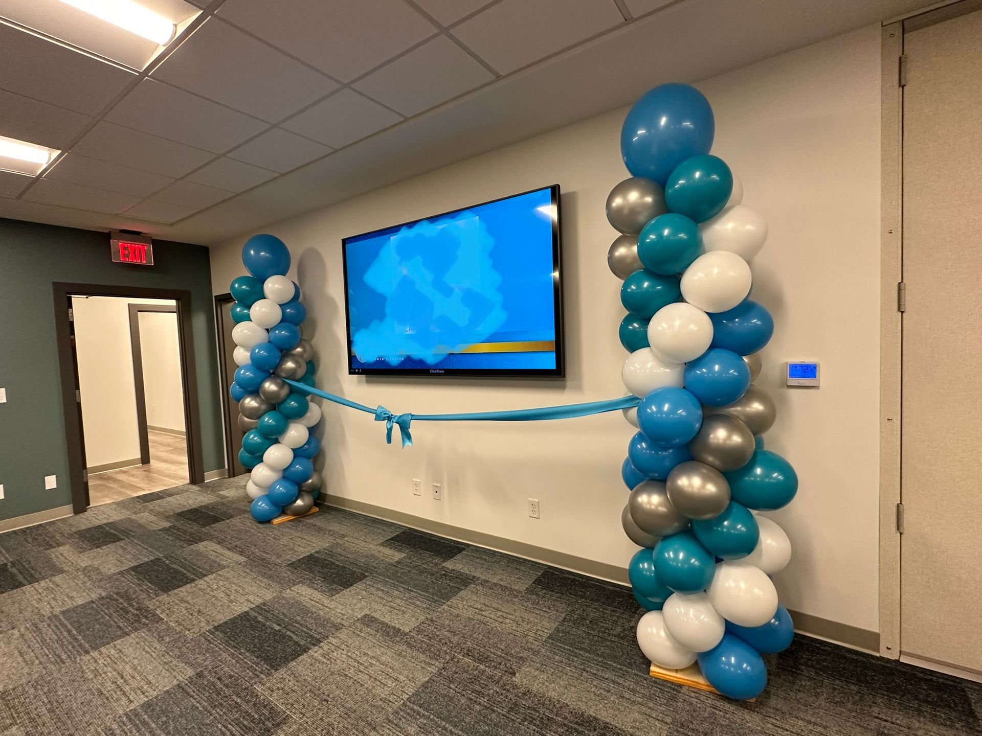 A room with balloons and a television on the wall