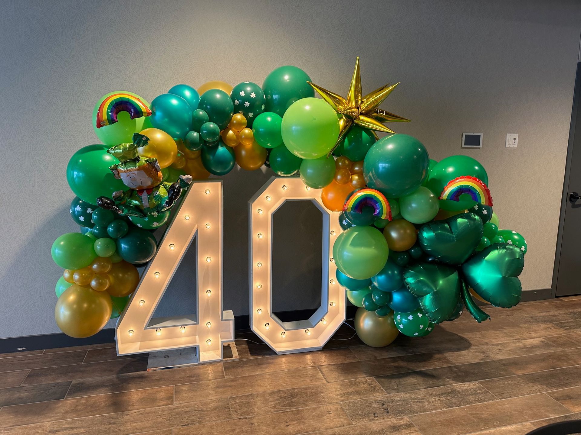A large number 40 is surrounded by green and gold balloons.