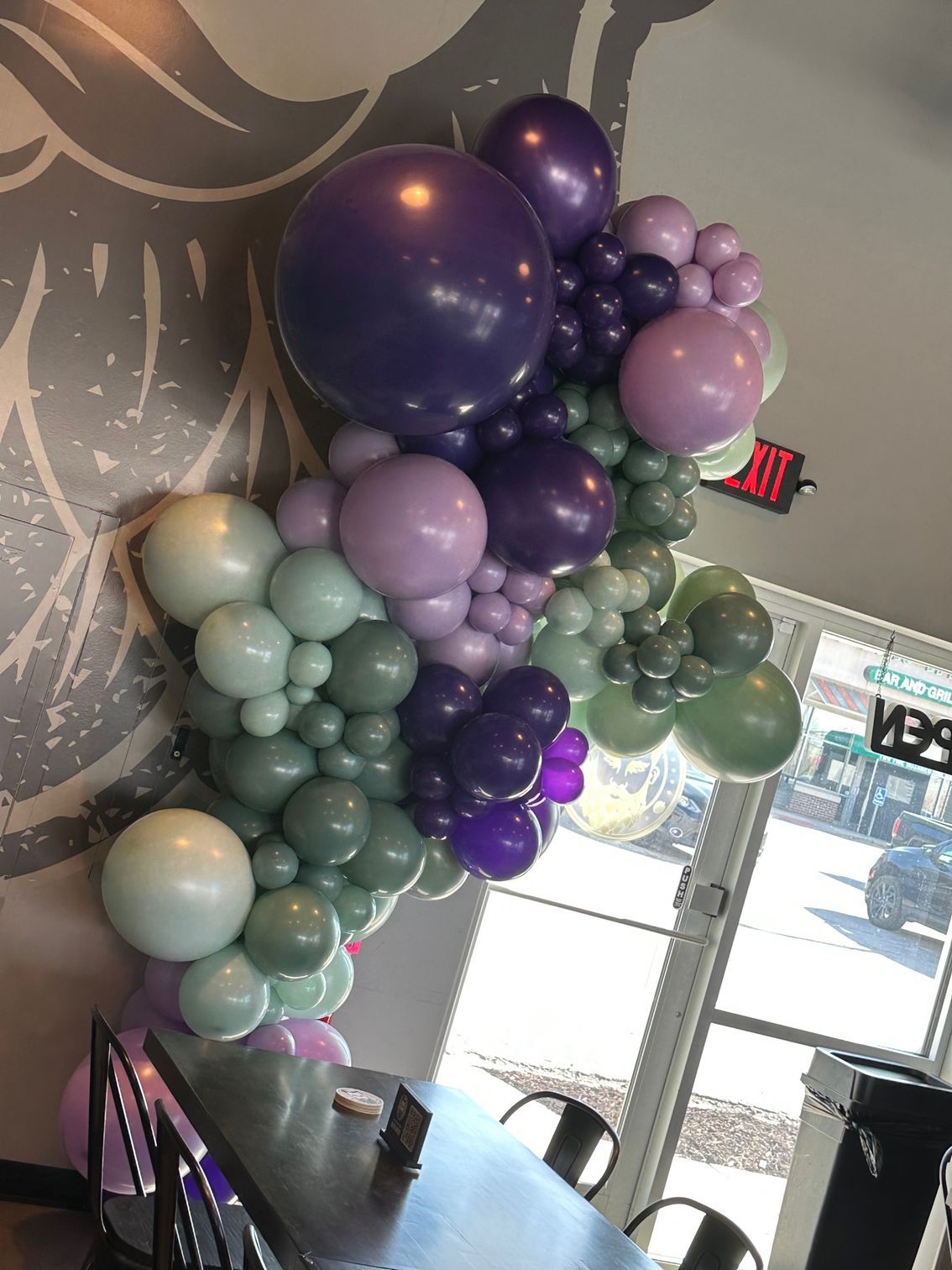 A bunch of balloons are hanging from the ceiling in a room.