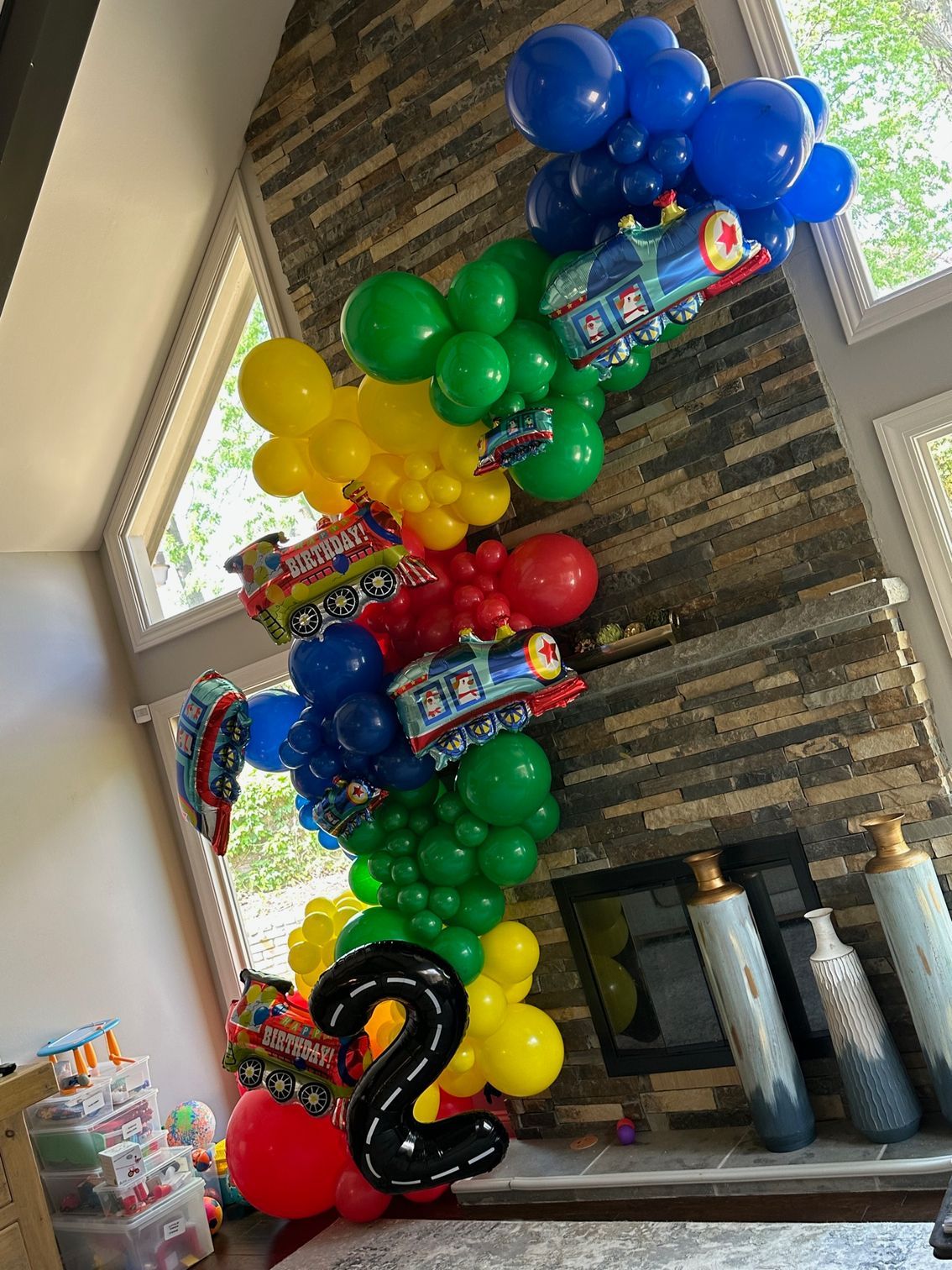 A bunch of balloons are stacked on top of each other in a living room.