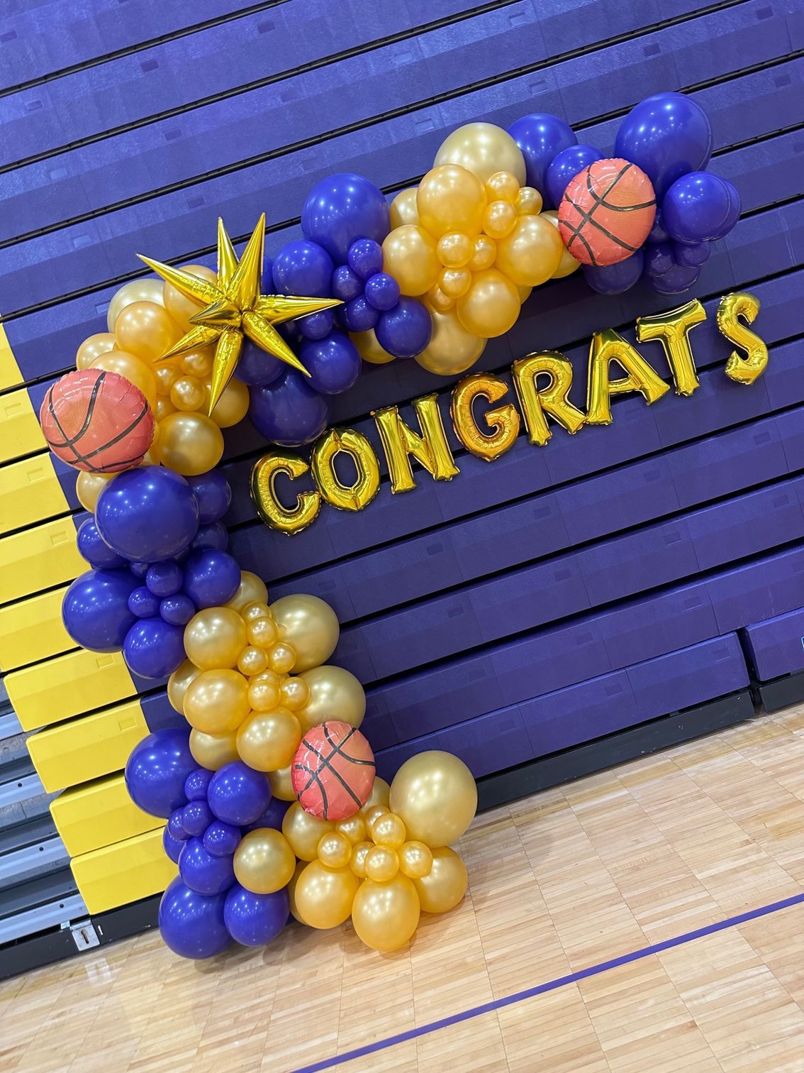 A basketball court decorated with balloons and the words `` congrats ''.