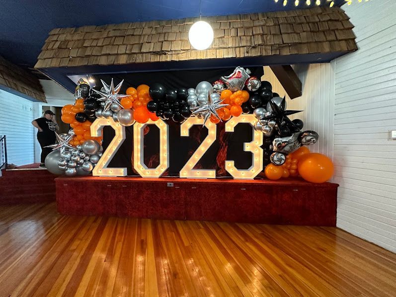 A room with balloons and a sign that says 2023