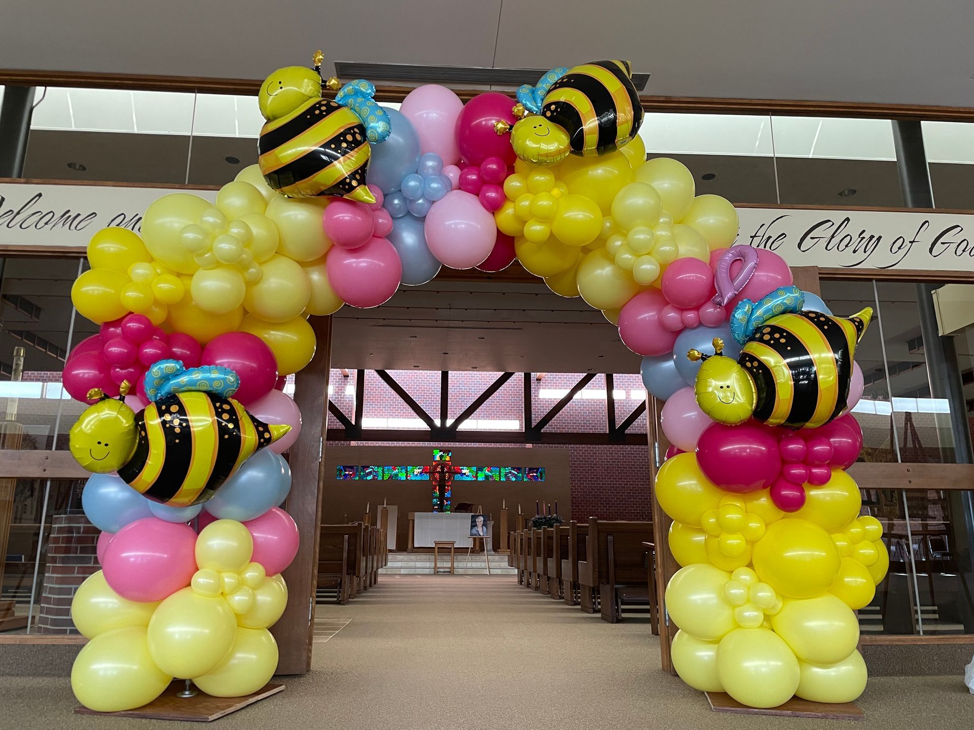 A large arch made of balloons with bees on it