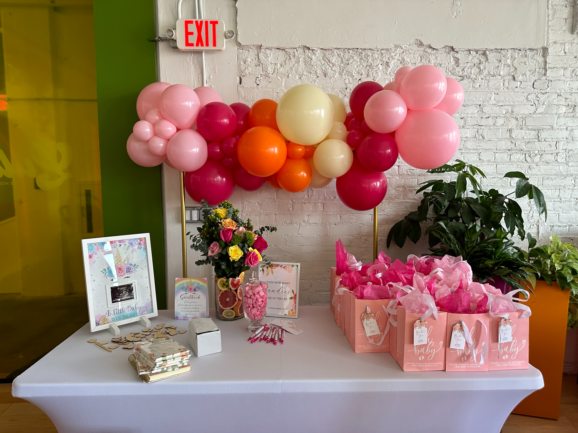 A table with balloons , flowers , candy , and a sign that says exit