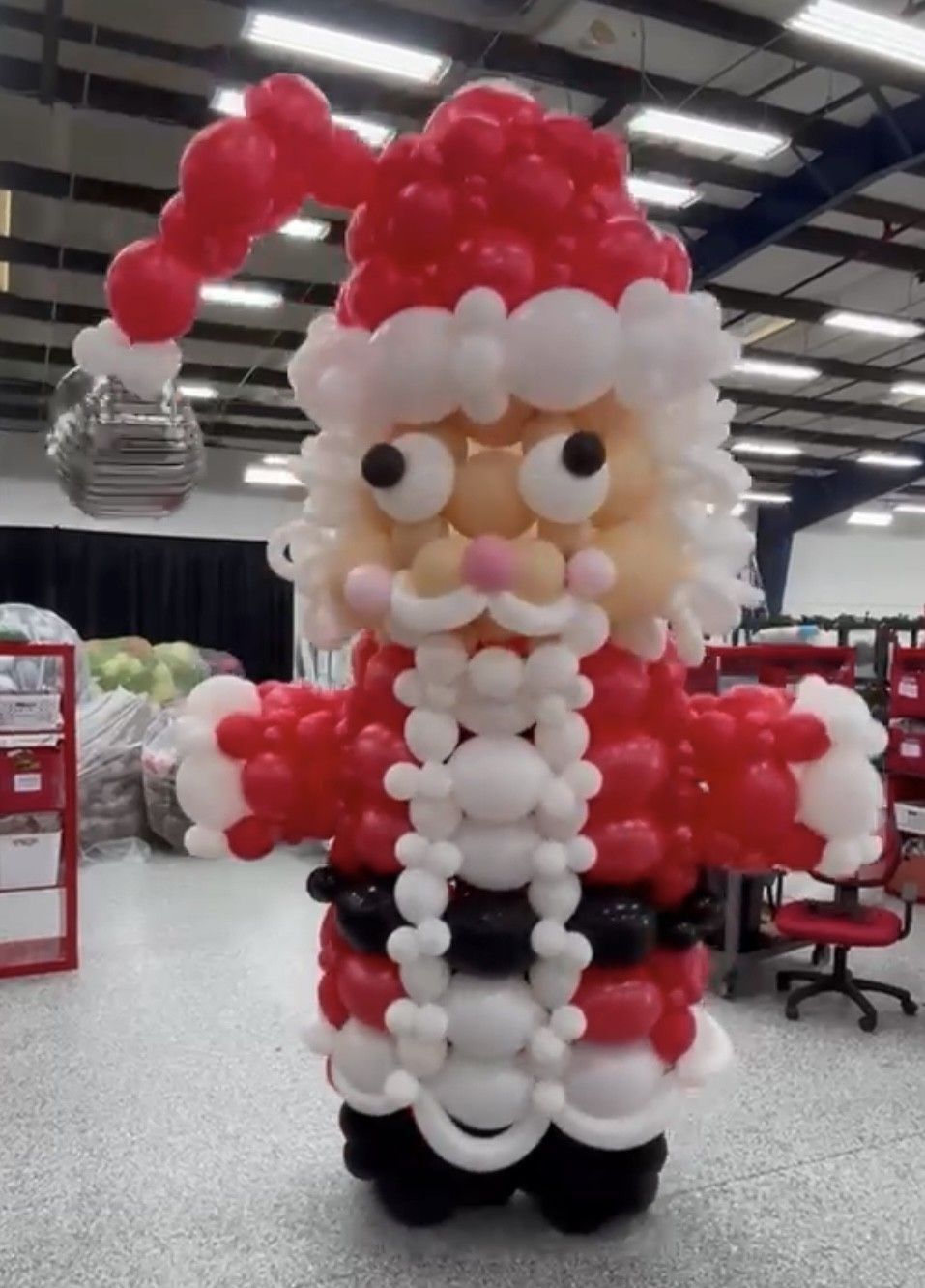 A santa claus made out of balloons in a room