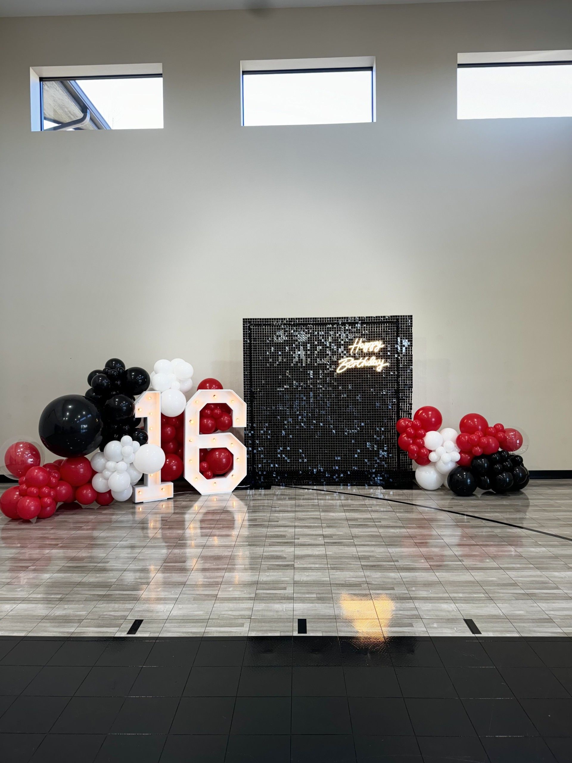 A room with balloons and a sign that says 16