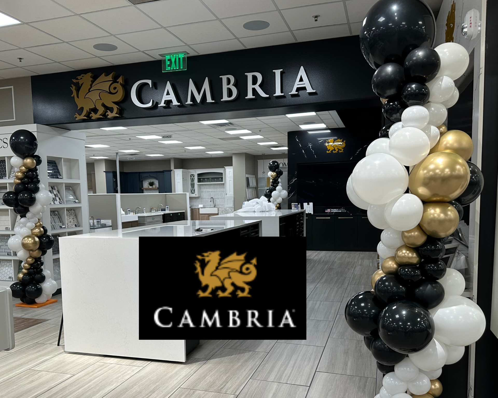 A cambria store is decorated with black and gold balloons