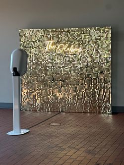 Photobooth with a shimmer wall and neon sign