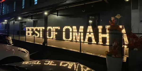 A sign that says best of omaha is lit up at night.