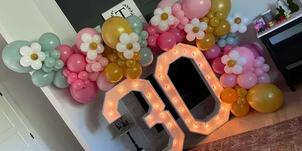 A room decorated with balloons and a lighted number 30.