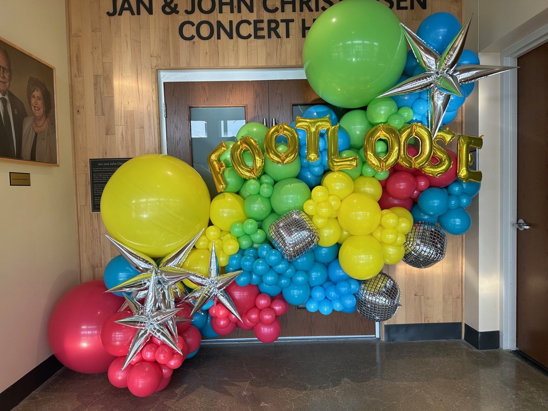 A wall of colorful balloons with the words footloose written on them