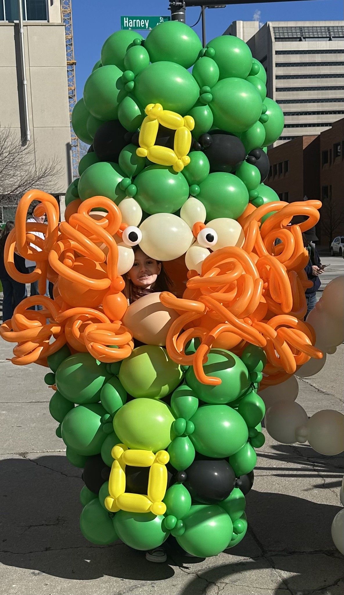 A leprechaun made out of green and orange balloons
