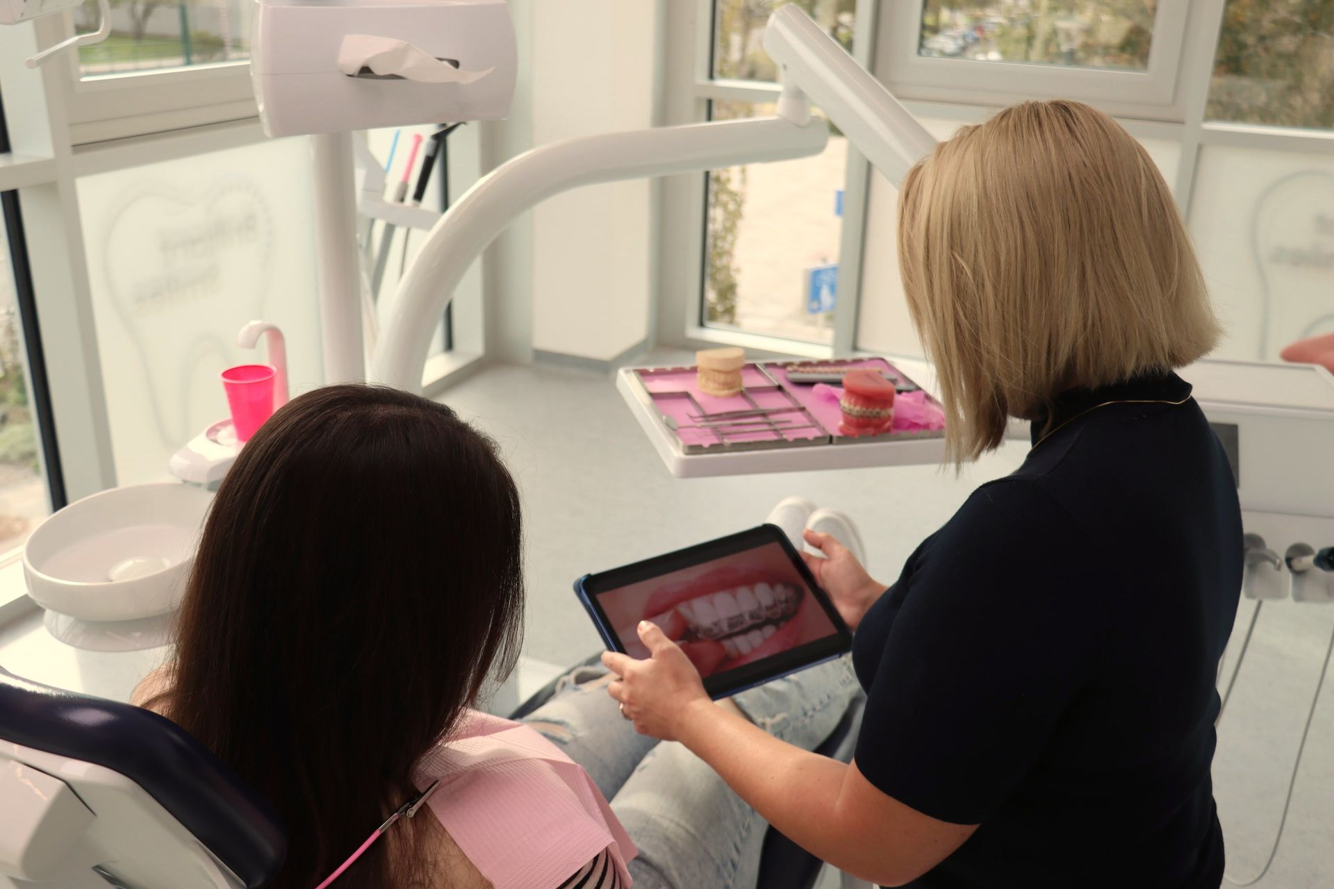 Zahnarzt zeigt Patientenscan der Zähne auf einem Tablet in der Zahnarztpraxis.