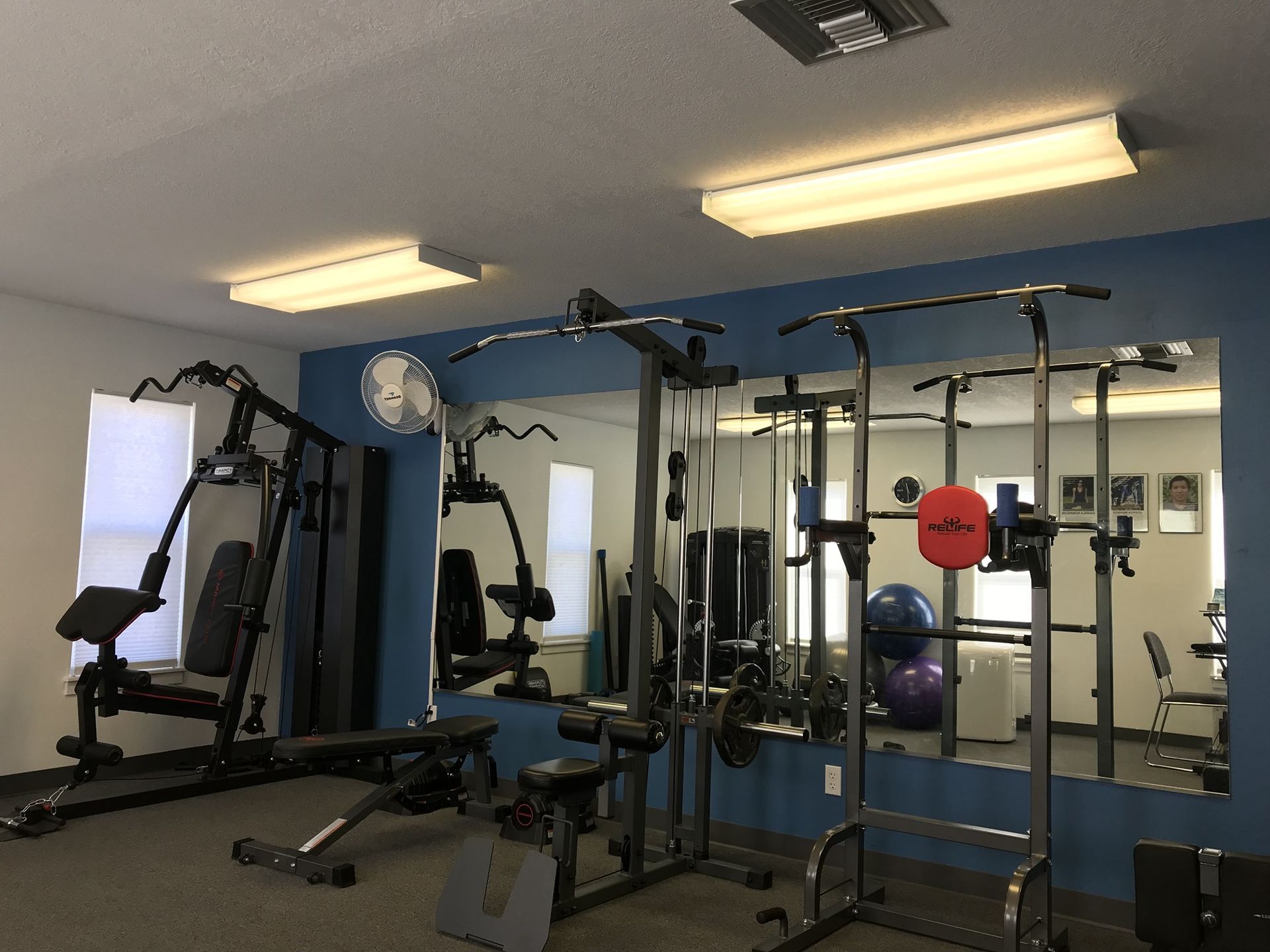 A gym with a lot of equipment and a large mirror