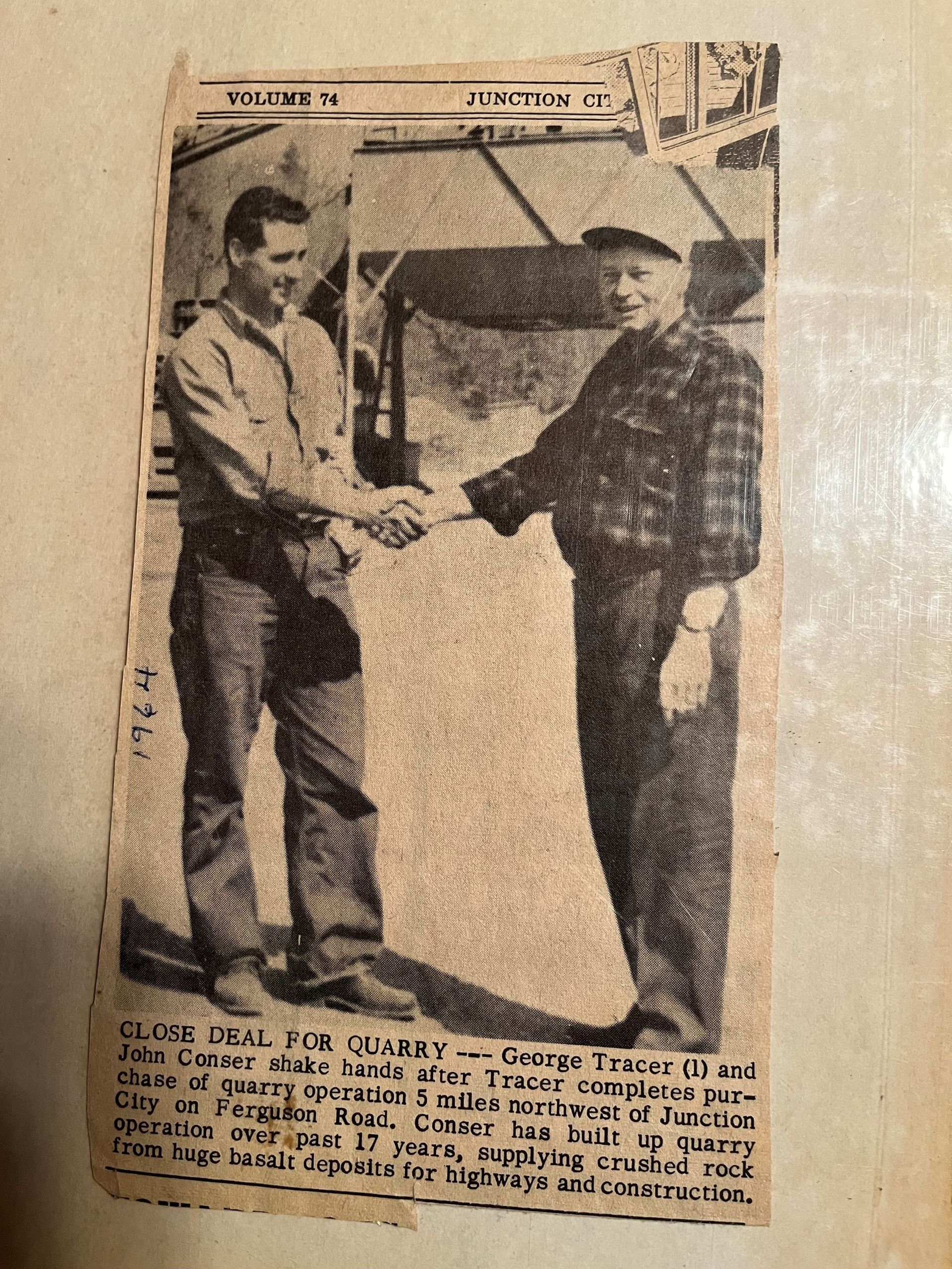 Two men are shaking hands in a black and white photo.