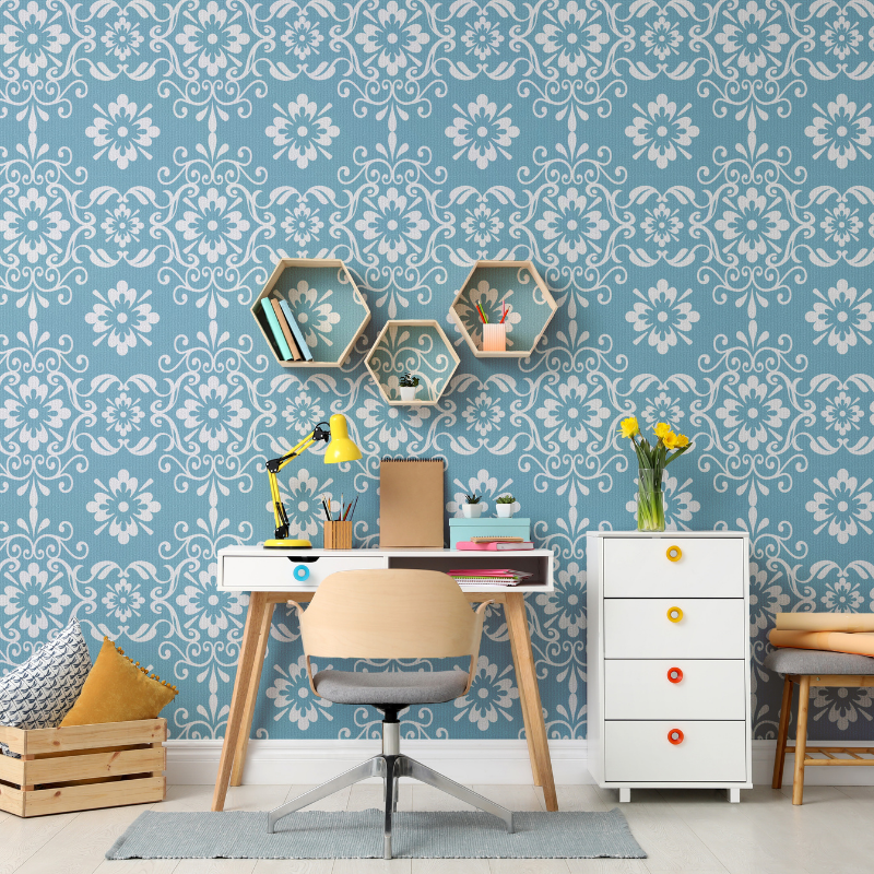 A desk and chair in a room with a blue wall