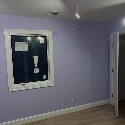 A room with purple walls and a window