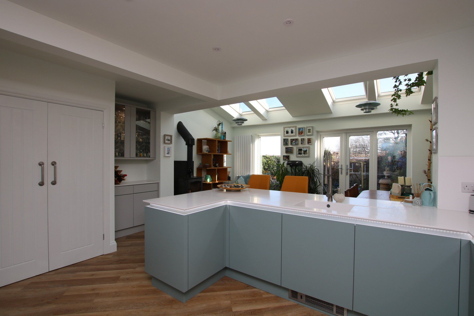 Modern kitchen with blue cabinets, white countertop, and skylights.